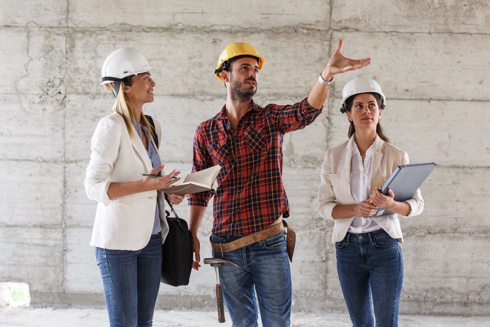 two,female,construction,inspectors,and,architects,discuss,with,head,engineer